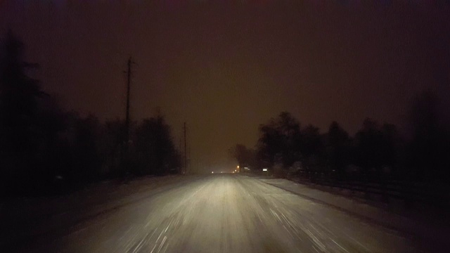 *倒车*在暴风雪中在乡村道路上行驶。司机观点POV冬季晚上的暴雨和向后的雪花视频素材