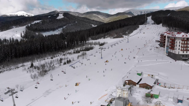 在滑雪胜地滑雪缆车附近滑雪斜坡上滑雪的许多人的鸟瞰图视频素材