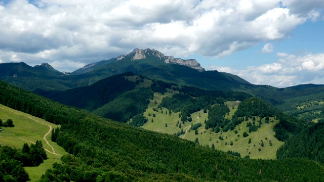 移动的云在岩石山，牧场和绿色森林的时间推移视频素材