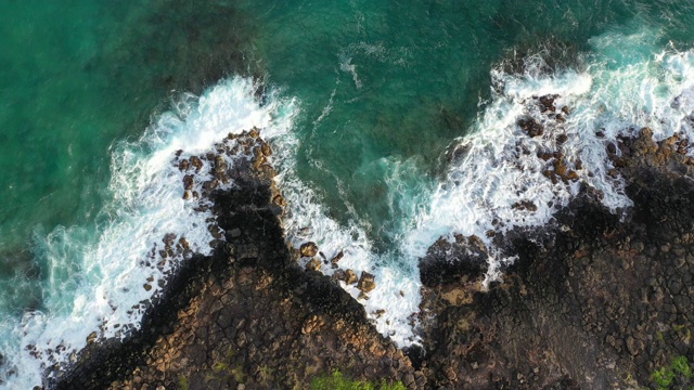 夏威夷火山岩石上蓝色海浪的鸟瞰图视频素材