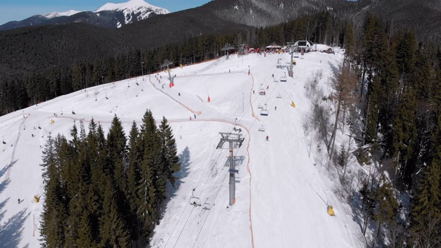 滑雪胜地的空中滑雪场与滑雪者和滑雪缆车。的雪山森林视频素材