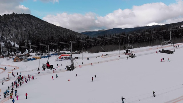 在滑雪胜地滑雪缆车附近滑雪斜坡上滑雪的许多人的鸟瞰图视频素材