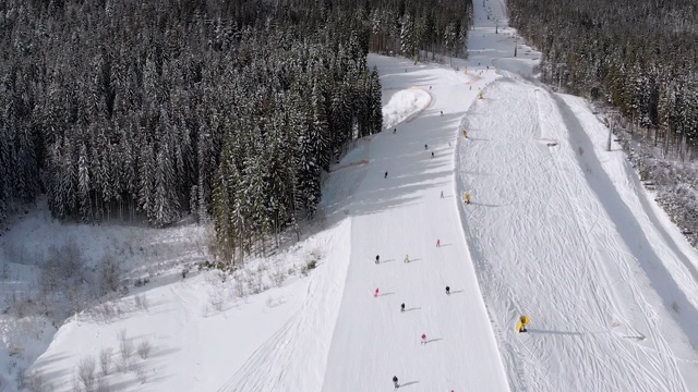 滑雪胜地的空中滑雪场与滑雪者和滑雪缆车。的雪山森林视频素材