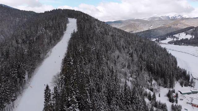 空中滑雪斜坡与滑雪者在滑雪胜地。雪山冷杉林。Bukovel视频素材