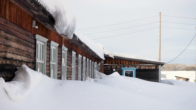 冬天的风景。位于西伯利亚的俄罗斯村庄，木屋被雪覆盖。俄罗斯4 k。视频素材