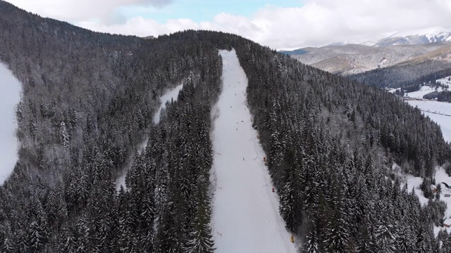 空中滑雪斜坡与滑雪者在滑雪胜地。雪山冷杉林。Bukovel视频素材