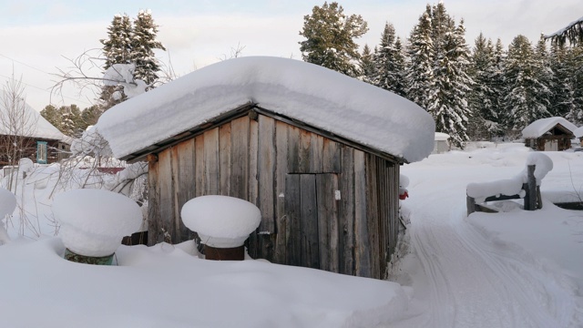 冬天的风景。位于西伯利亚的俄罗斯村庄，木屋被雪覆盖。俄罗斯4 k。视频素材