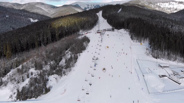 空中滑雪斜坡与滑雪者在滑雪胜地。雪山冷杉林。Bukovel视频素材