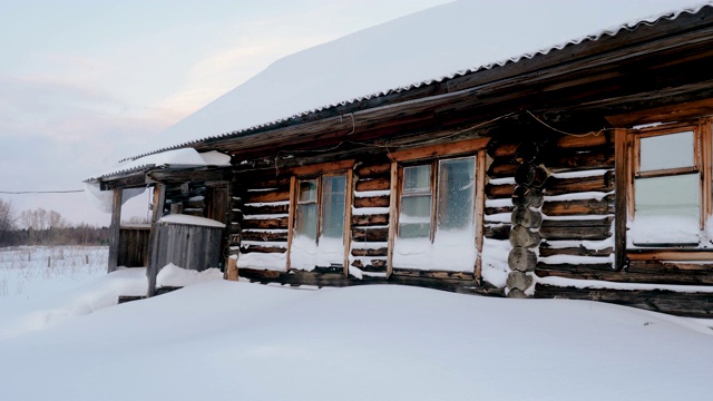 白雪覆盖的松林中的木屋。俄罗斯乡村冬季景观。西伯利亚。4 k视频素材