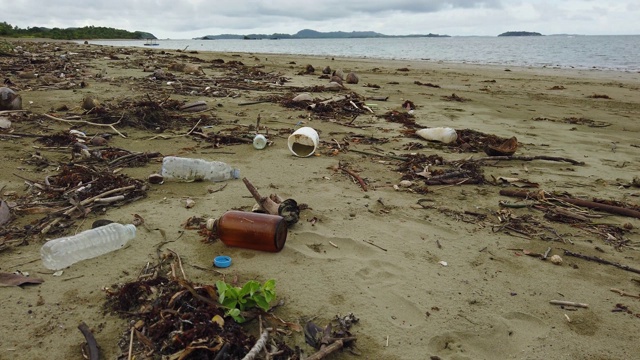 海滩污染。塑料瓶和海滩上的其他垃圾。海洋污染视频素材