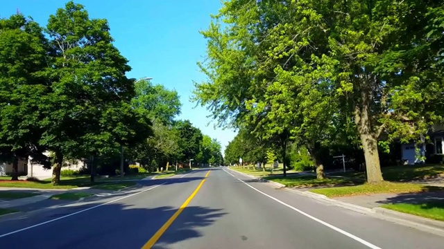 *倒车*驾驶城市郊区街道在夏天说倒。司机视角POV郊区城市住宅道路。视频素材