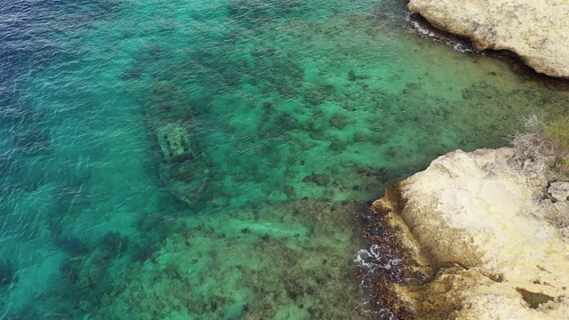 航拍周围拖船海滩- Curaçao -加勒比海绿松石水，悬崖，海滩和美丽的珊瑚礁视频素材