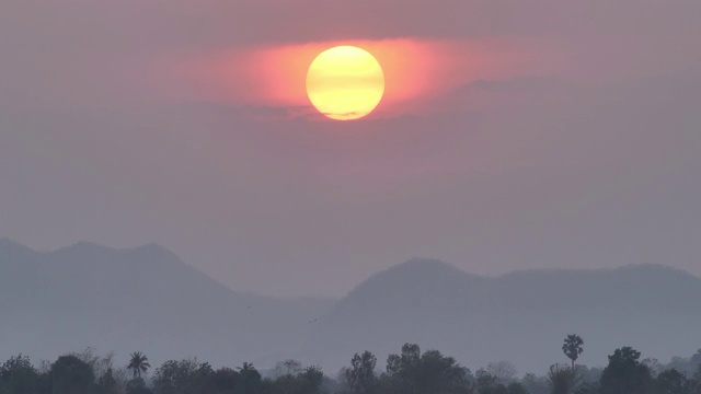 美丽的大日落在晚上的天空。背景红红的夕阳满山，森林视频素材