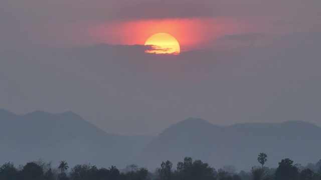 美丽的大日落在晚上的天空。背景红红的夕阳满山，森林视频素材