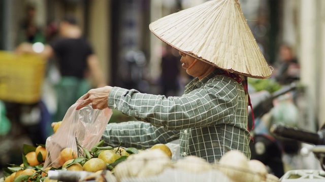 手持的越南妇女在市场上卖水果视频素材