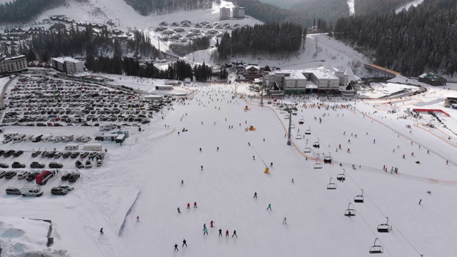 在滑雪胜地滑雪缆车附近滑雪斜坡上滑雪的许多人的鸟瞰图视频素材