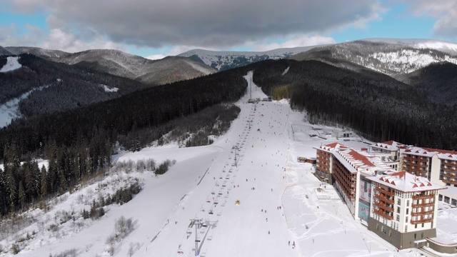 空中滑雪斜坡与滑雪者在滑雪胜地。雪山冷杉林。Bukovel视频素材