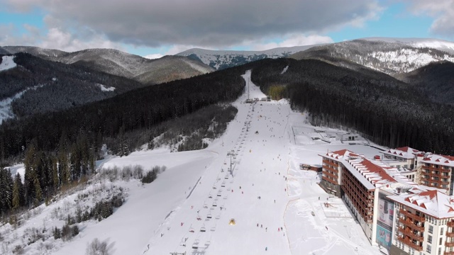 在滑雪胜地滑雪缆车附近滑雪斜坡上滑雪的许多人的鸟瞰图视频素材