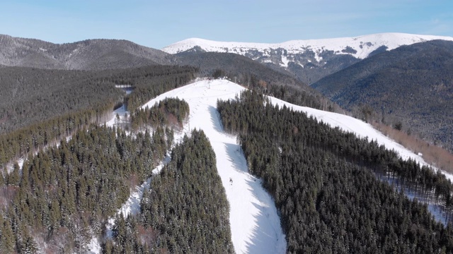 滑雪胜地的空中滑雪场与滑雪者和滑雪缆车。的雪山森林视频素材