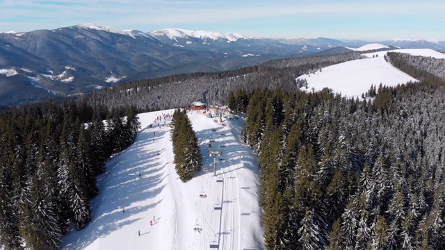 滑雪胜地的空中滑雪场与滑雪者和滑雪缆车。的雪山森林视频素材