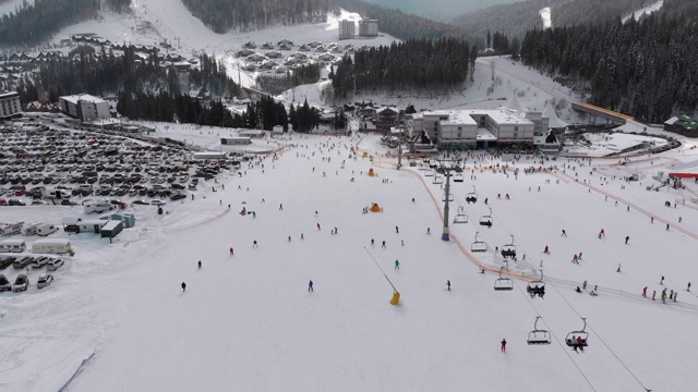 在滑雪胜地滑雪缆车附近滑雪斜坡上滑雪的许多人的鸟瞰图视频素材