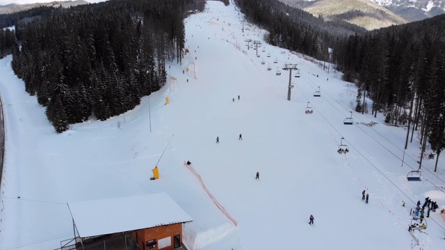 鸟瞰冬季滑雪场的滑雪坡道及滑雪缆车视频素材