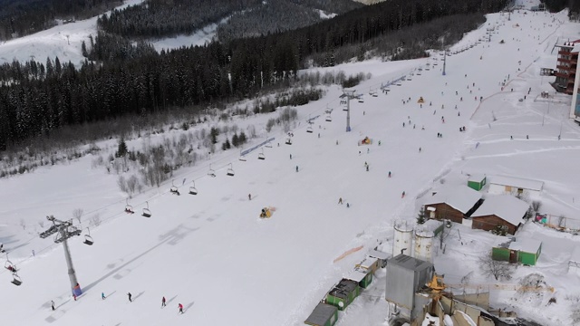 鸟瞰图滑雪者去滑雪胜地滑雪缆车附近的滑雪斜坡。Bukovel视频素材