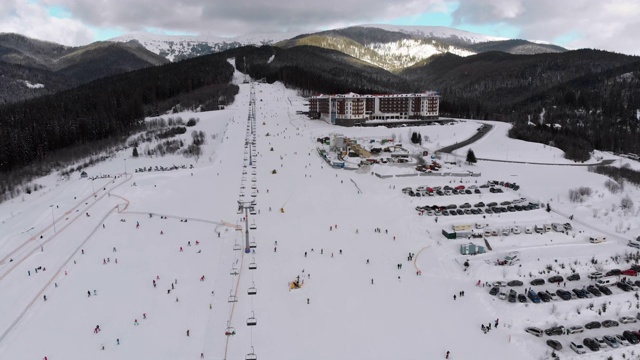 在滑雪胜地滑雪缆车附近滑雪斜坡上滑雪的许多人的鸟瞰图视频素材