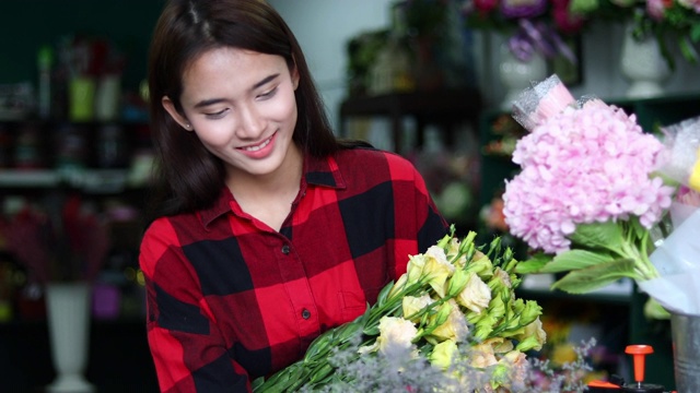 亚洲妇女花店小生意花店老板和她正在用她的电话和笔记本电脑为她的商店接受订单。视频素材