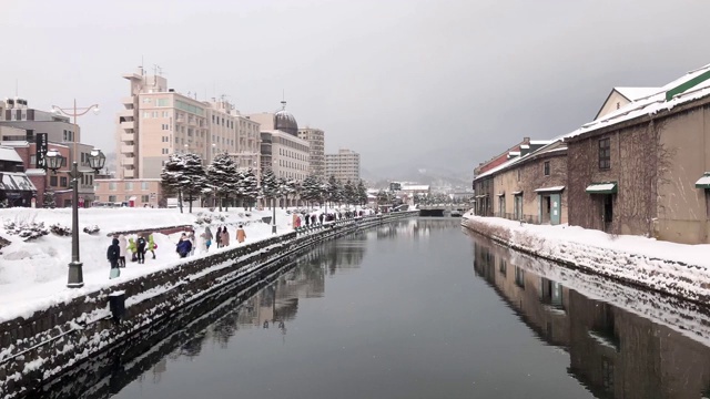 4K时间推移:小丸运河的冬季历史地标，人们在下雪时散步视频素材