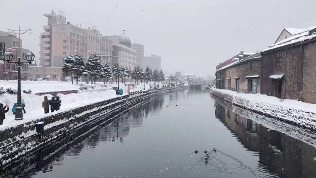 4K时间推移:小丸运河的冬季历史地标，人们在下雪时散步视频素材