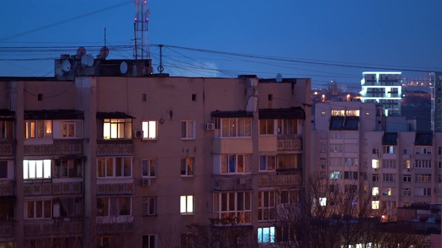 城市夜景，黄昏时分，住宅楼的窗户闪闪发光视频素材