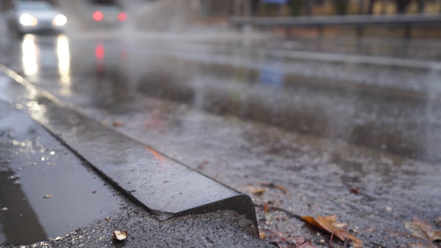 在秋天的雨天，在潮湿的道路上模糊的城市交通。视频素材