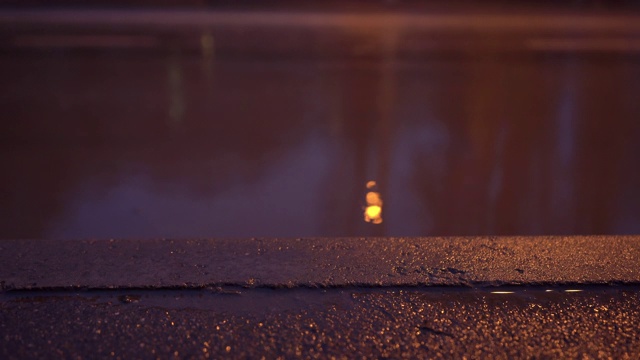 秋季多雨的夜晚城市街道，潮湿的人行道和城市交通道路被淹没视频素材