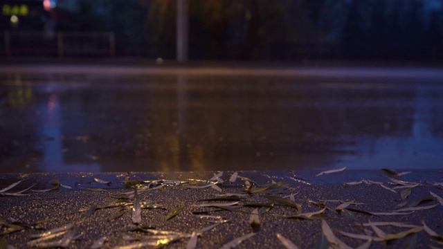 秋季多雨的夜晚城市街道，潮湿的人行道和城市交通道路被淹没视频素材