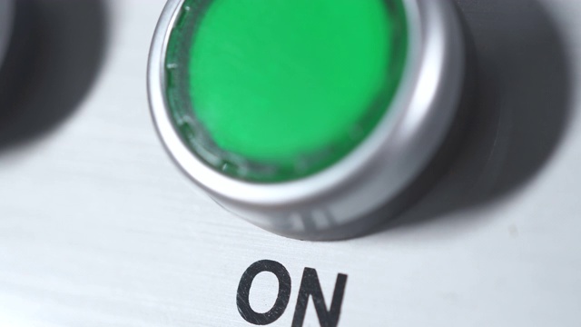 绿色按钮上电。手指推按钮。在工业工厂启动发动机电气设备。面板采用绿色塑料圆形按钮。工作的开始。开关。接通电视频素材