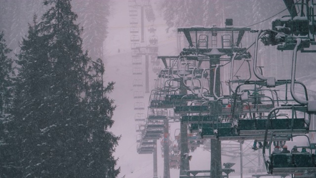 滑雪胜地的滑雪缆车，慢动作。滑雪者爬上滑雪椅电梯去滑雪斜坡视频素材