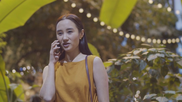 亚洲女人在植物咖啡馆里打电话视频素材