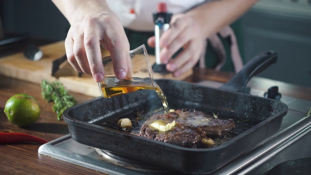 厨师在烤盘上制作火焰风格的牛排。油和酒精用明火燃烧。在烹饪食物。营养在美食厨房。做顿饭。准备吃的食物。美味的菜。视频素材