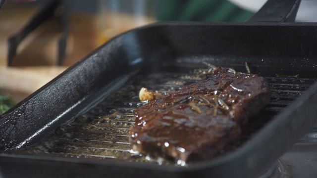 餐厅厨师把酱汁倒在烤盘里的牛排上。烹饪食谱。准备菜肴。健康营养的美食厨房。做顿饭。准备吃的食物。美味的菜。视频素材