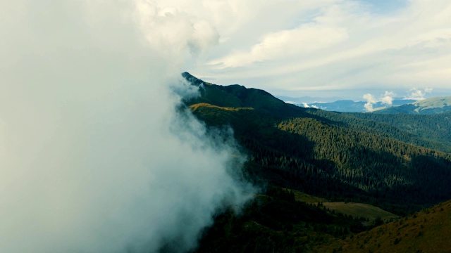 在高山森林上空如画的云中飞行视频素材