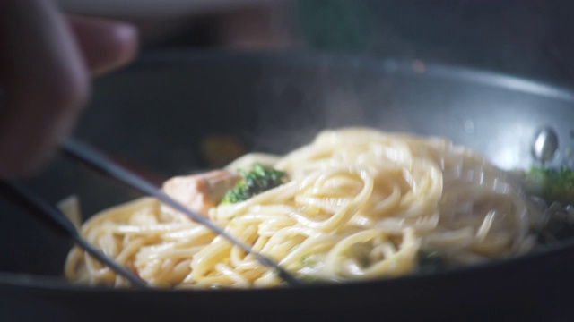 厨师在餐厅厨房的平底锅里搅拌现成的意大利面。食品成分。烹饪美食。烹饪美食。准备吃的食物。美食烹饪。美味的晚餐。视频素材