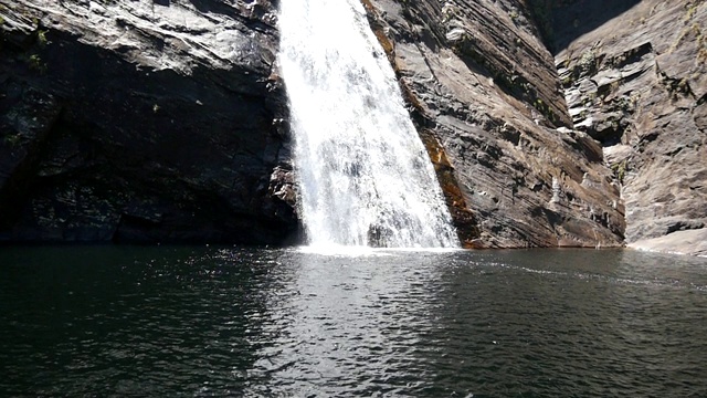 令人惊叹的长多层次瀑布瀑布垂直岩石悬崖面在热带雨林。淡水小溪在亚洲岛屿的山上落下。美丽的自然背景。升降镜头视频素材