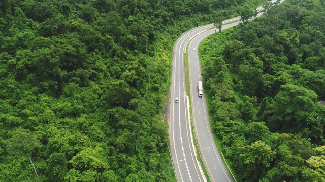 鸟瞰图卡车在森林中行驶。卡车在空中拍摄的电影道路视频素材