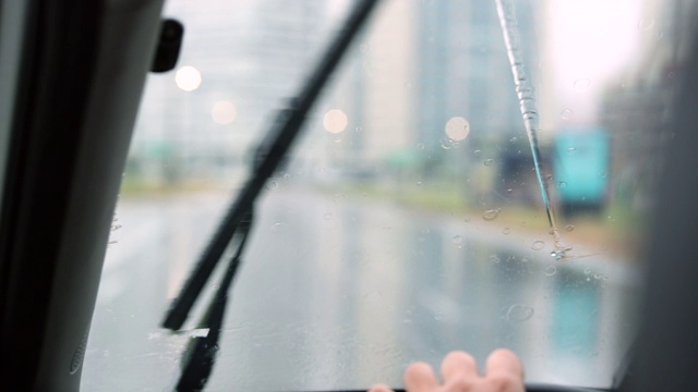 雨天在路上行驶时，汽车挡风玻璃刮水器在运动视频素材