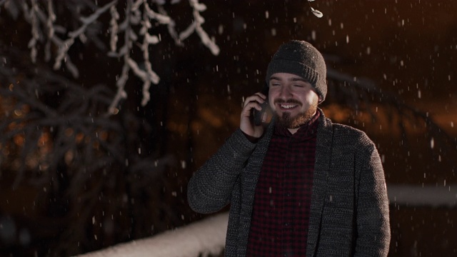 男人打电话，站在户外的山上滑雪基地。股票视频视频素材