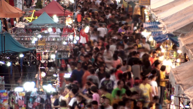 在泰国曼谷的一个购物街节上，人群在当地市场上移动视频素材