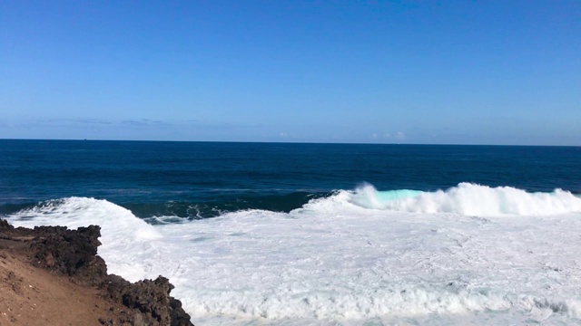 在蓝色和清澈的海面上形成巨大的波浪从上面的视野形成的波浪在地平线上和撞击海岸在慢动作捕捉120帧/秒。视频素材