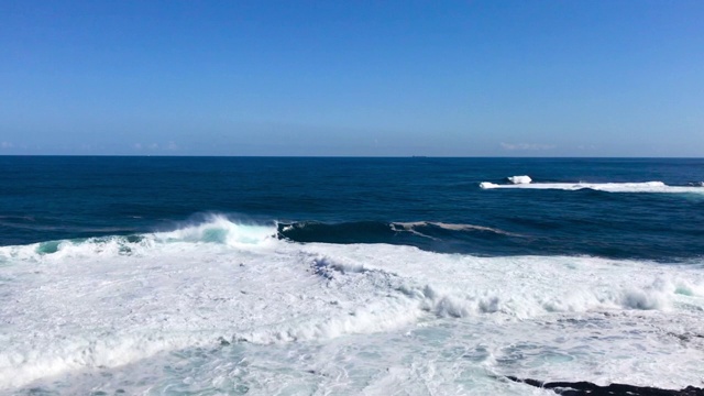 在蓝色和清澈的海面上形成巨大的波浪从上面的视野形成的波浪在地平线上和撞击海岸在慢动作捕捉120帧/秒。视频素材