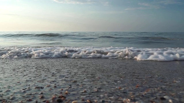 海滩，泡沫的海洋，海浪冲刷着沙子。海浪冲击着沙滩。海浪声视频素材